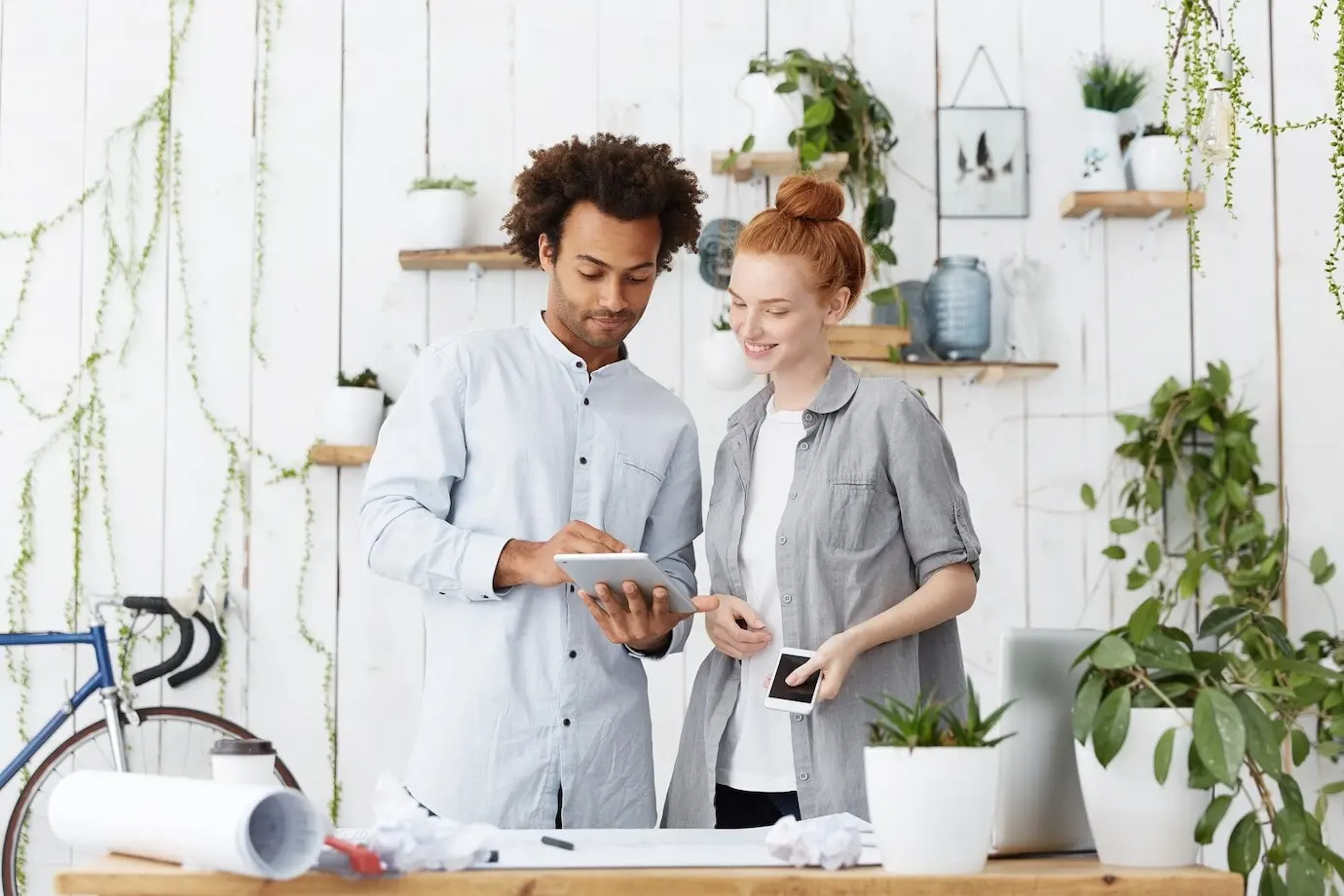 Ein junges Familienpaar unterschiedlicher ethnischer Herkunft entwirft die Baupläne für sein zukünftiges Haus.